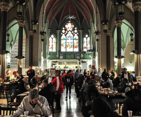 A group of people sitting at tables in a church.