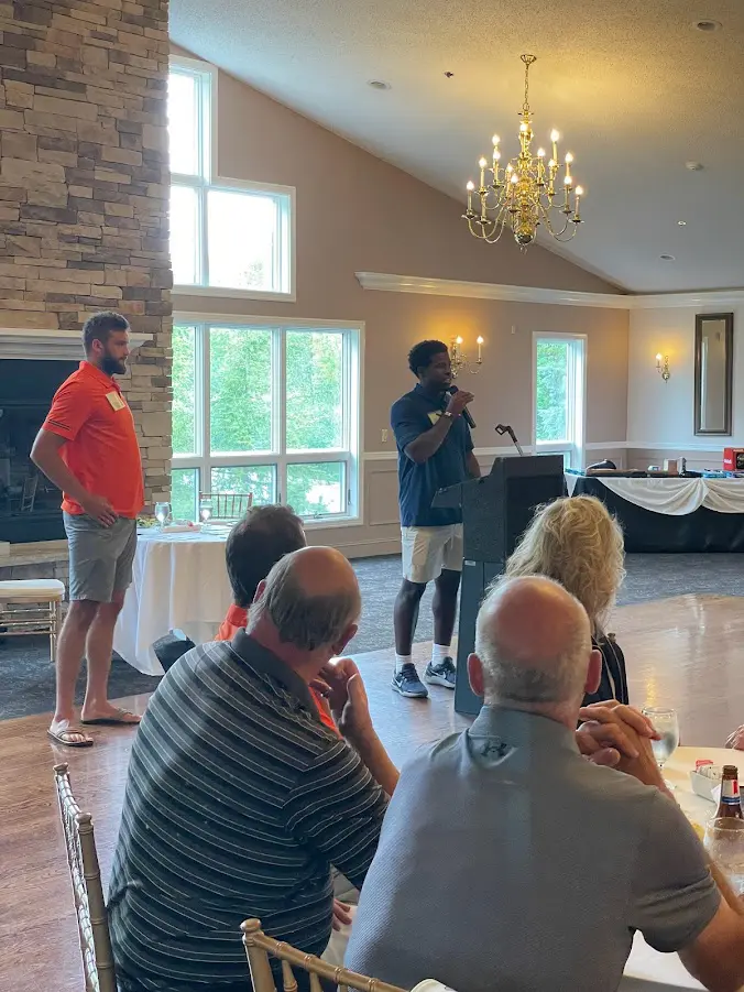 SU Football Player Marlowe Wax speaks to the crowd during dinner about what volunteering means to him and his teammates.