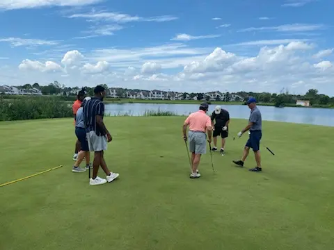 Golfers joined SU Football players on the green near the water.